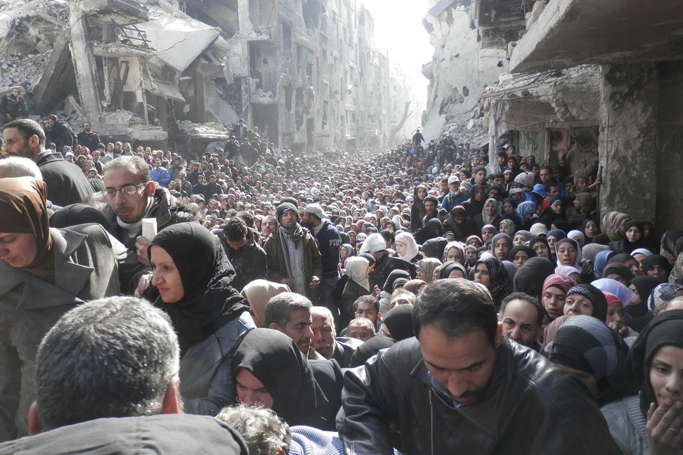 Residents of the Yarmouk camp gather in a food distribution line in January 2014 (UNRWA)