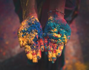 Hands covered in colorful dust.
