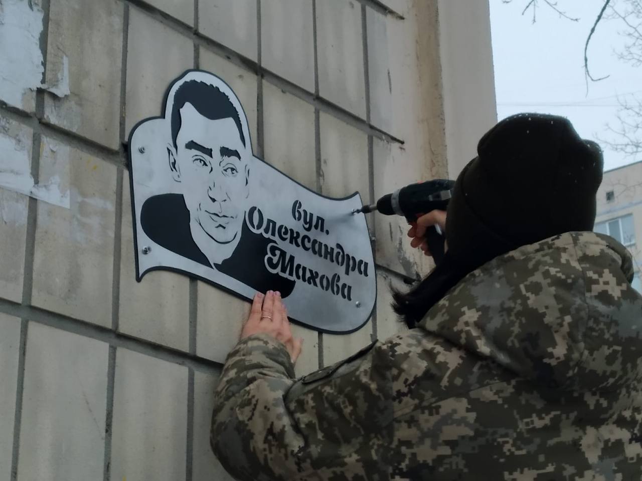 Anastasiya Blyshchyk installs a sign in honor of fiancé Oleksandr Makhov on Makhov Street in Kyiv in November 2022. Photo provided by Blyshchyk.