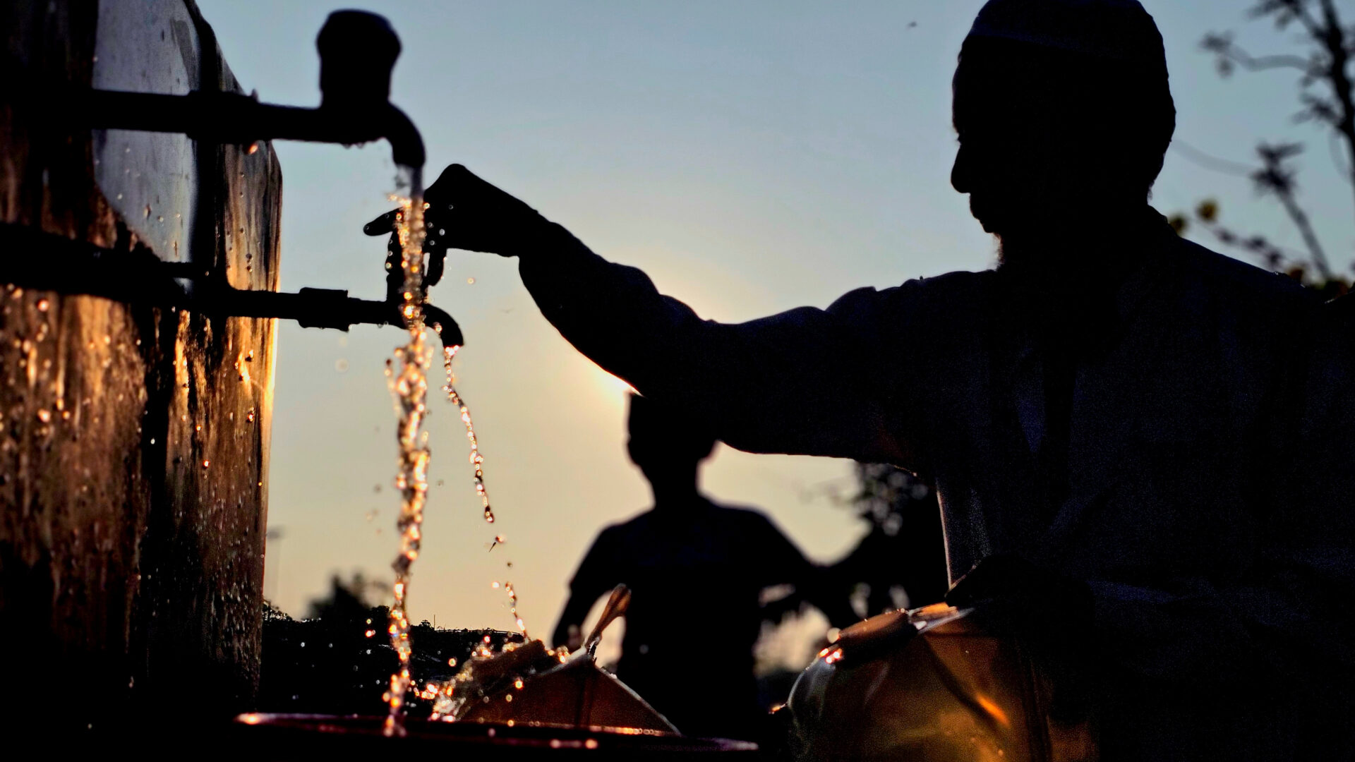 A man in a Rohingya refugee camp in Cox's Bazar, Bangladesh, draws water from a communal tap (Sahat Zia Hero)
