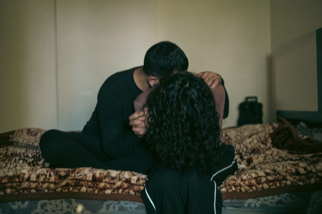 Maya and Jad sit together on the bed of their one-room apartment north of Beirut (João Sousa)