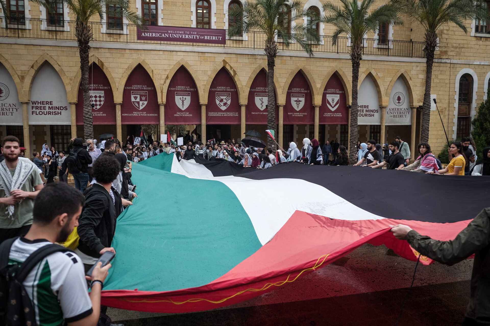 Students unfurl a Palestinian flag at a protest on the American University of Beirut campus, April 30, 2024 (João Sousa)