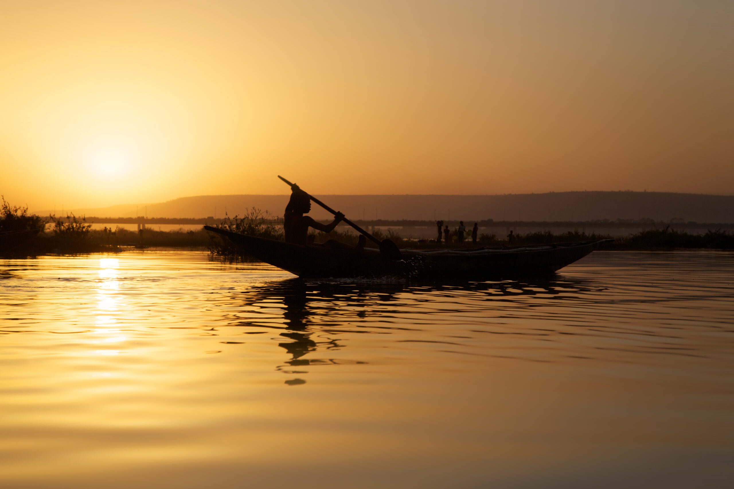 Local cruising on the river Niger in Bamako with sunset
