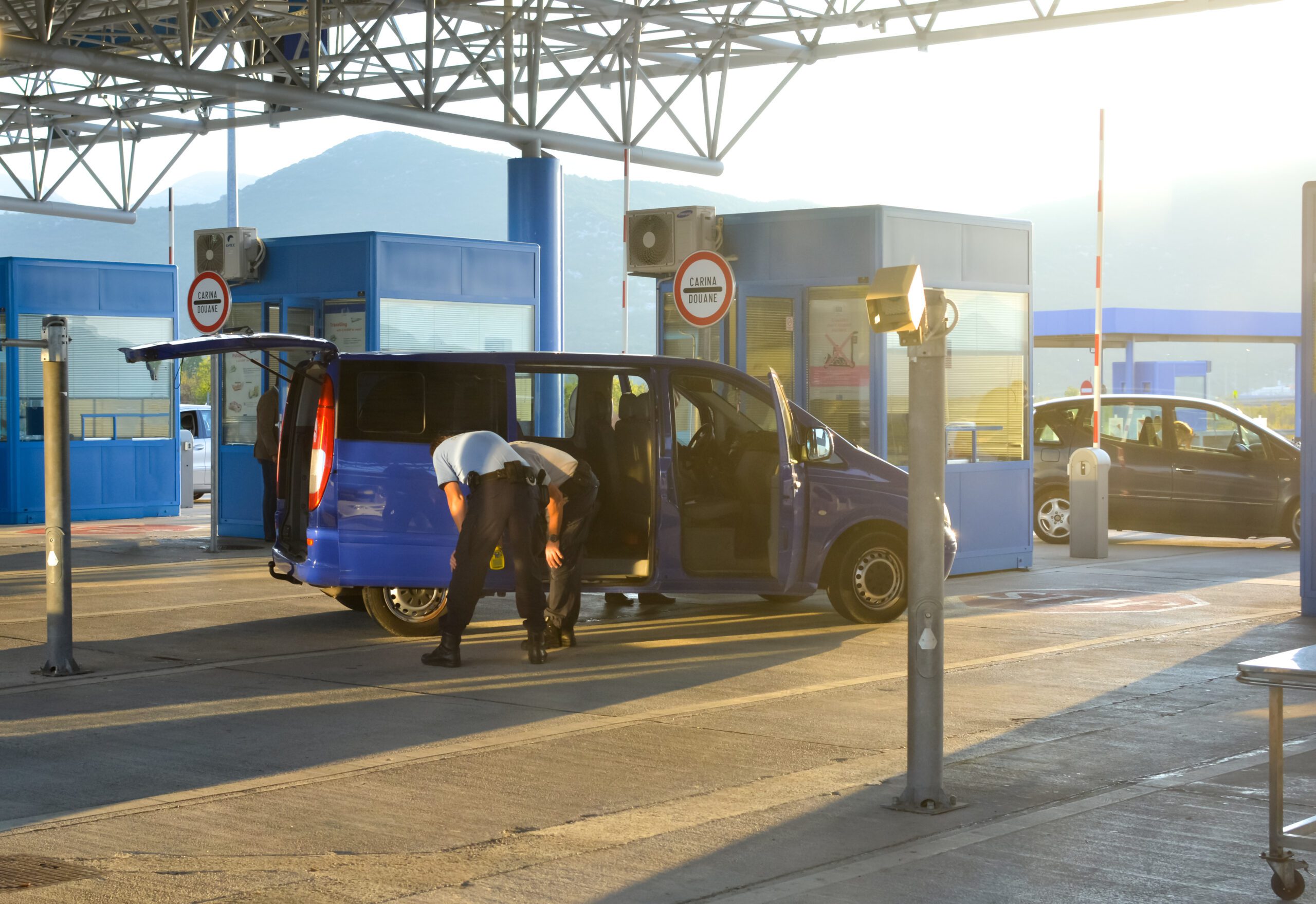A van is stopped and checked by two inspectors at the border crossing at Ivanica between Bosnia and Herzegovina and Croatia.