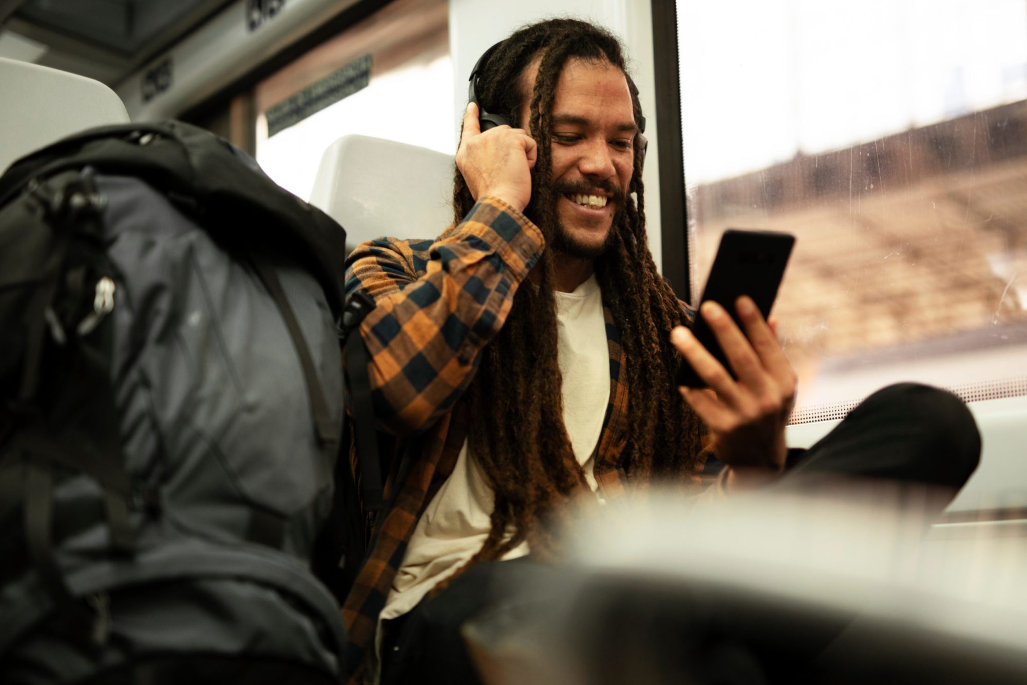 Young man listening the music while traveling by a train. Handso