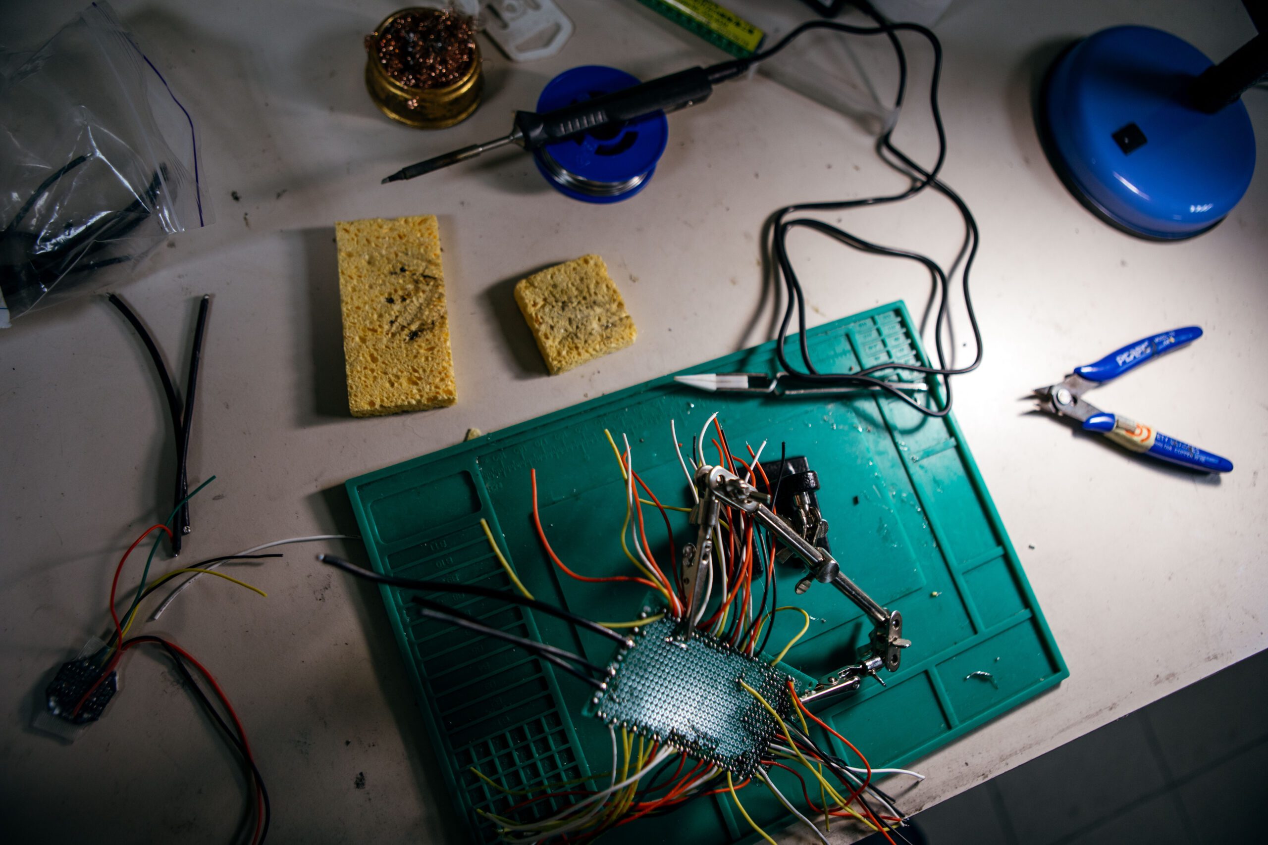 A workshop station at Klyn where a volunteer is practicing soldering
