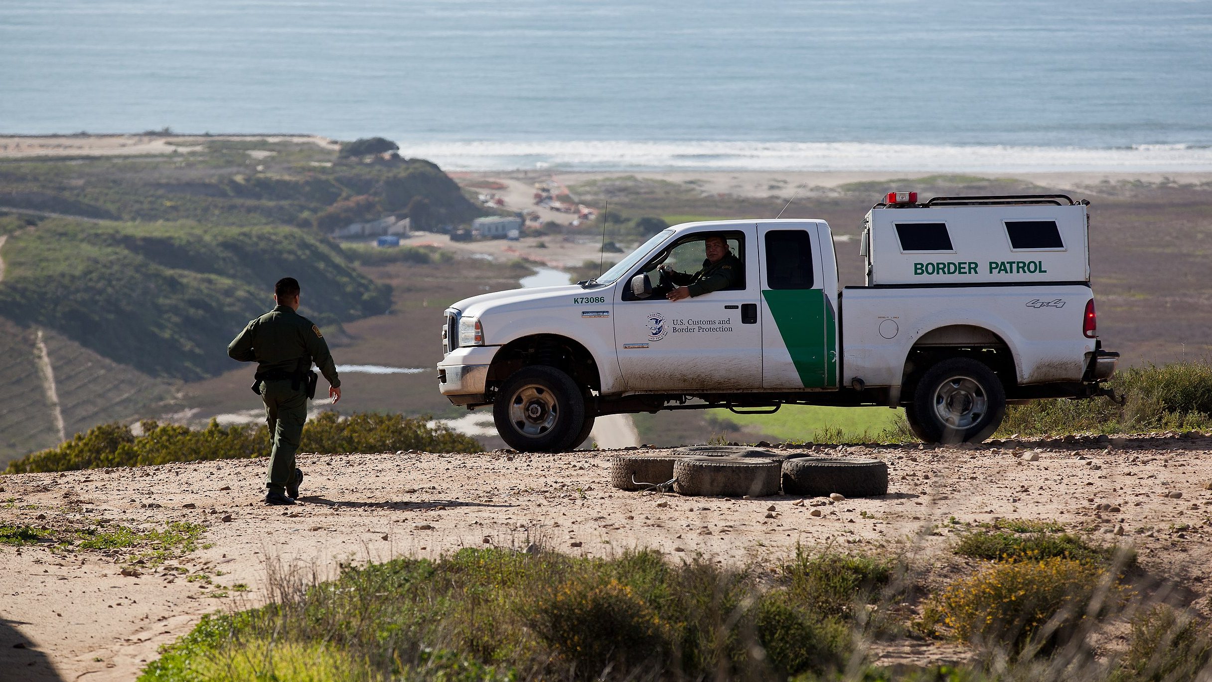 A Border Patrol SUV is parked near the border on a hill overlooking Friendship Beach in February 2012 (Josh Denmark/Wikimedia Commons)