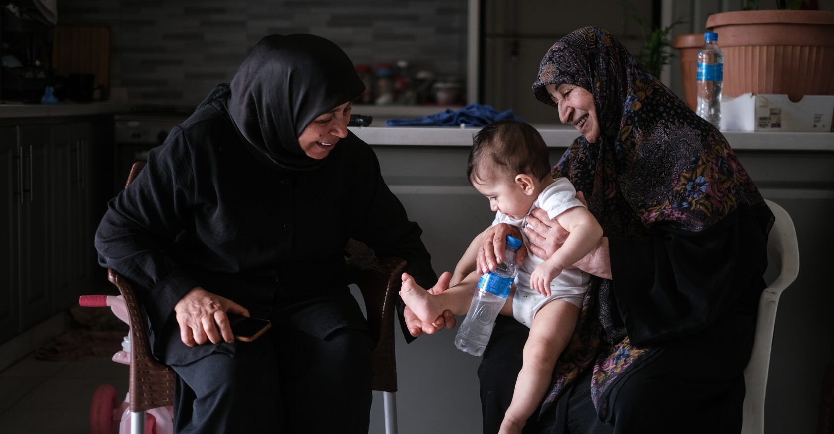 Siham and Aida hold Aida's granddaughter (João Sou