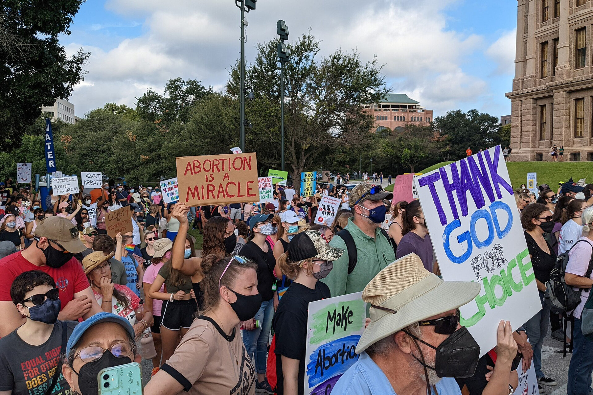 Crowd at a rally against SB 8 at the Texas Capitol, with a sign reading "abortion is a miracle" in October 2021 (Jno.Skinner via Wikimedia Commons)