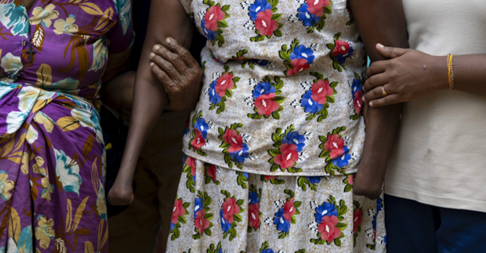 A woman who losts both of her hands to a landmine explosion is held by others (Dimitra Margariti)