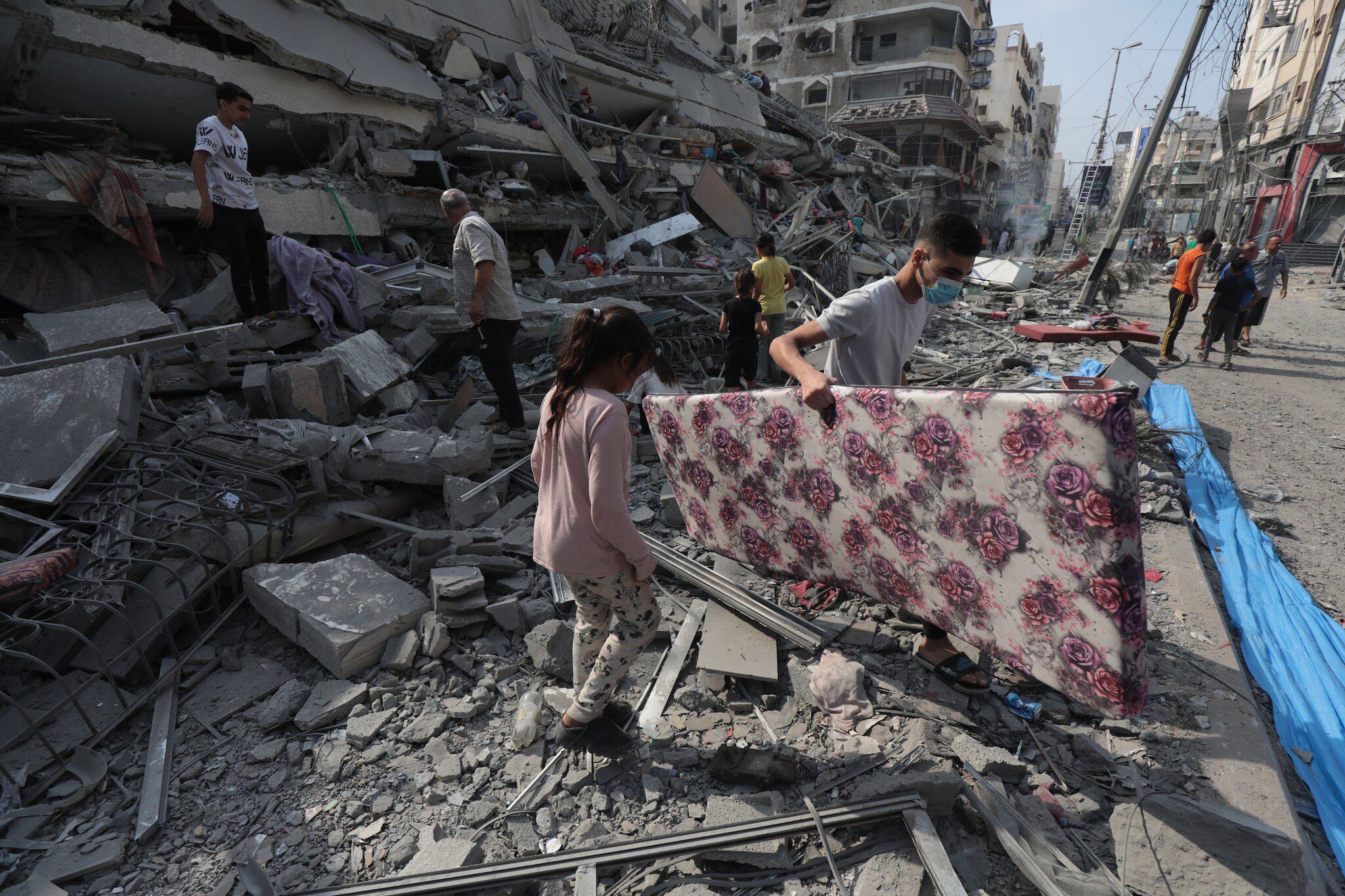 Palestinians inspect the ruins of Aklouk Tower destroyed in Israeli airstrikes in Gaza City on October 8, 2023 (Wafa Agency via Wikimedia Commons)