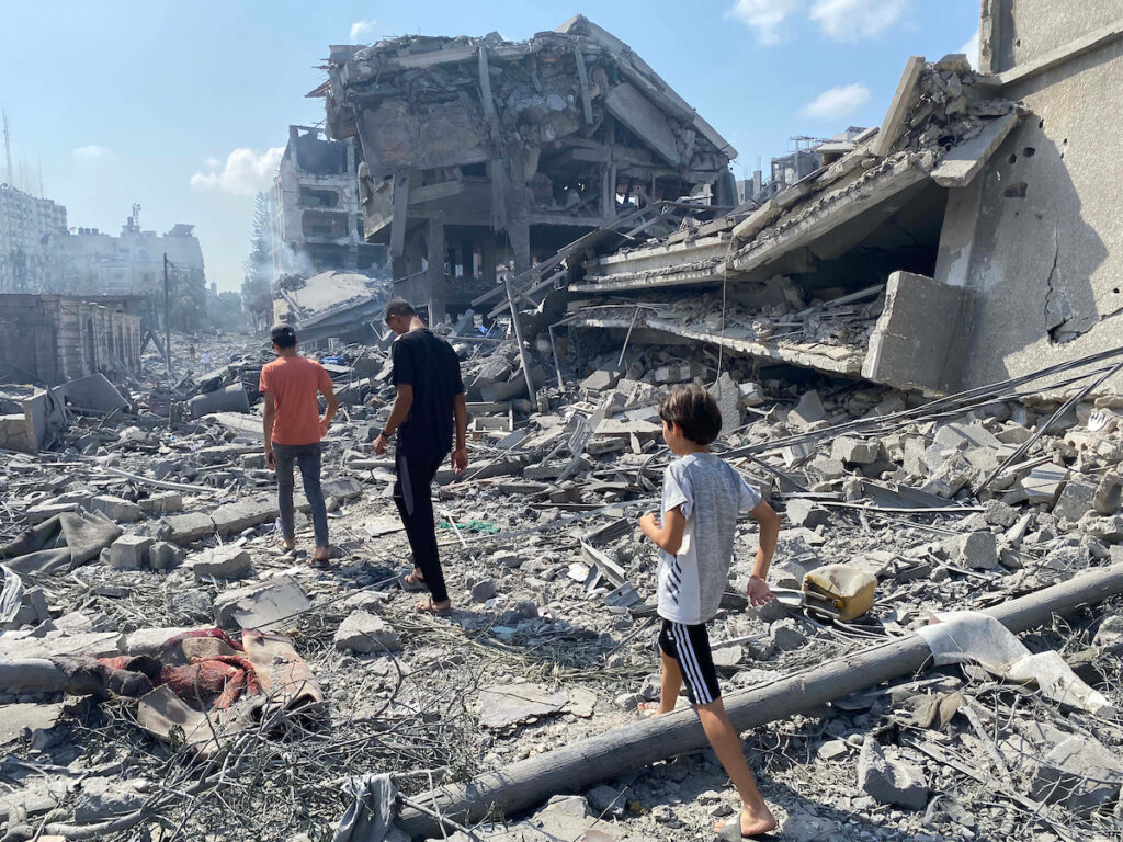 Palestinians inspect the damage following an Israeli airstrike on the al-Remal area in Gaza City on Oct. 9, 2023 (WAFA/Wikimedia Commons)