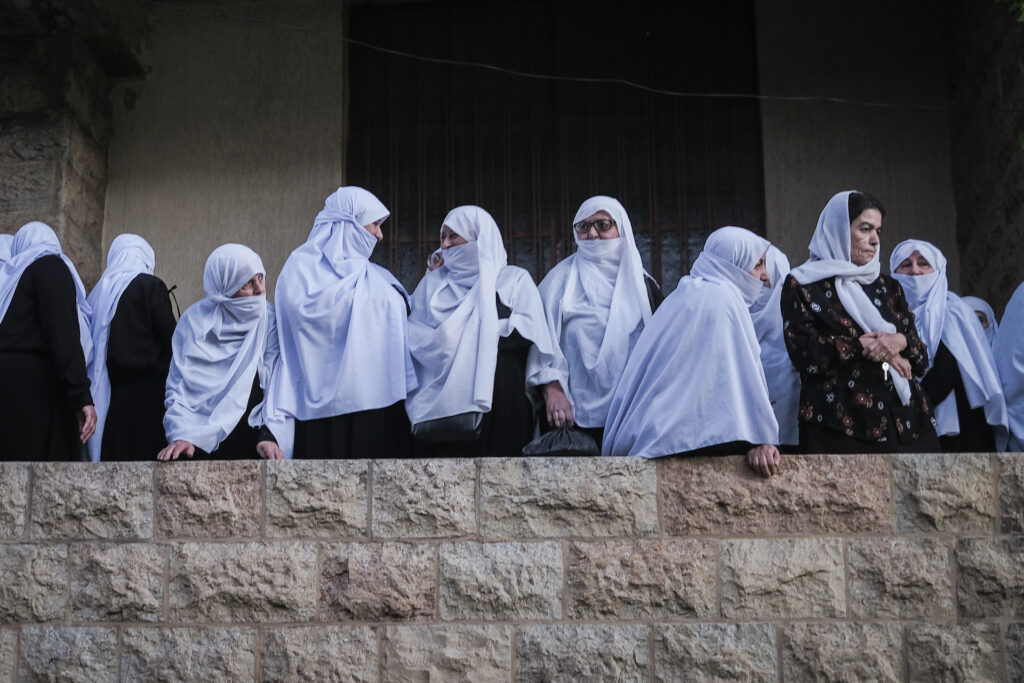 Women gather on a balcony overlooking Baysour’s main square just before sunrise for the town’s annual Liqaa al-Eid tradition on Eid al-Adha, where religious sheikhs greet one another. June 16, 2024 (João Sousa)