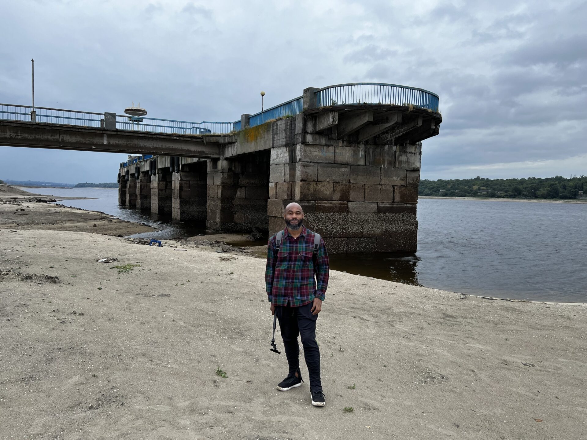 Terrell Jermaine Starr standing on sand at the Dnieper River where water used to be in Zaporizhzhia, Ukraine on July 28, 2023. The water level at the river dropped drastically after the Russians blew up the Kakhovka dam, causing an ecological disaster.