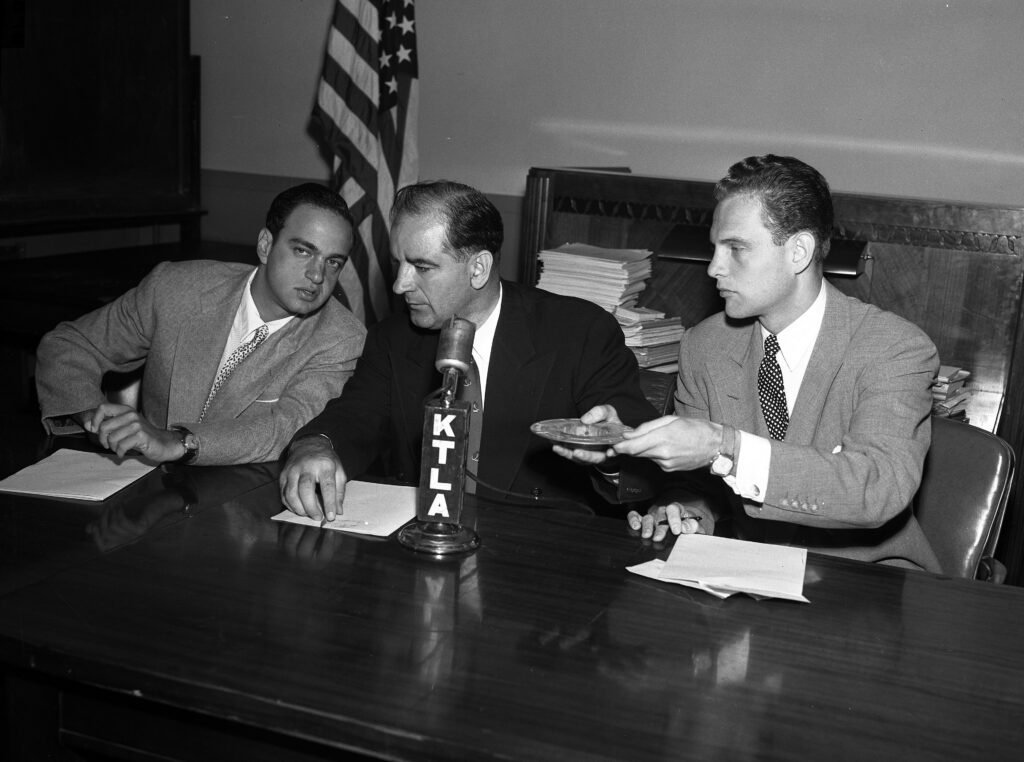 McCarthy (center) speaks with Roy Cohn (left) during questioning in August 1953 (Los Angeles Times/UCLA)