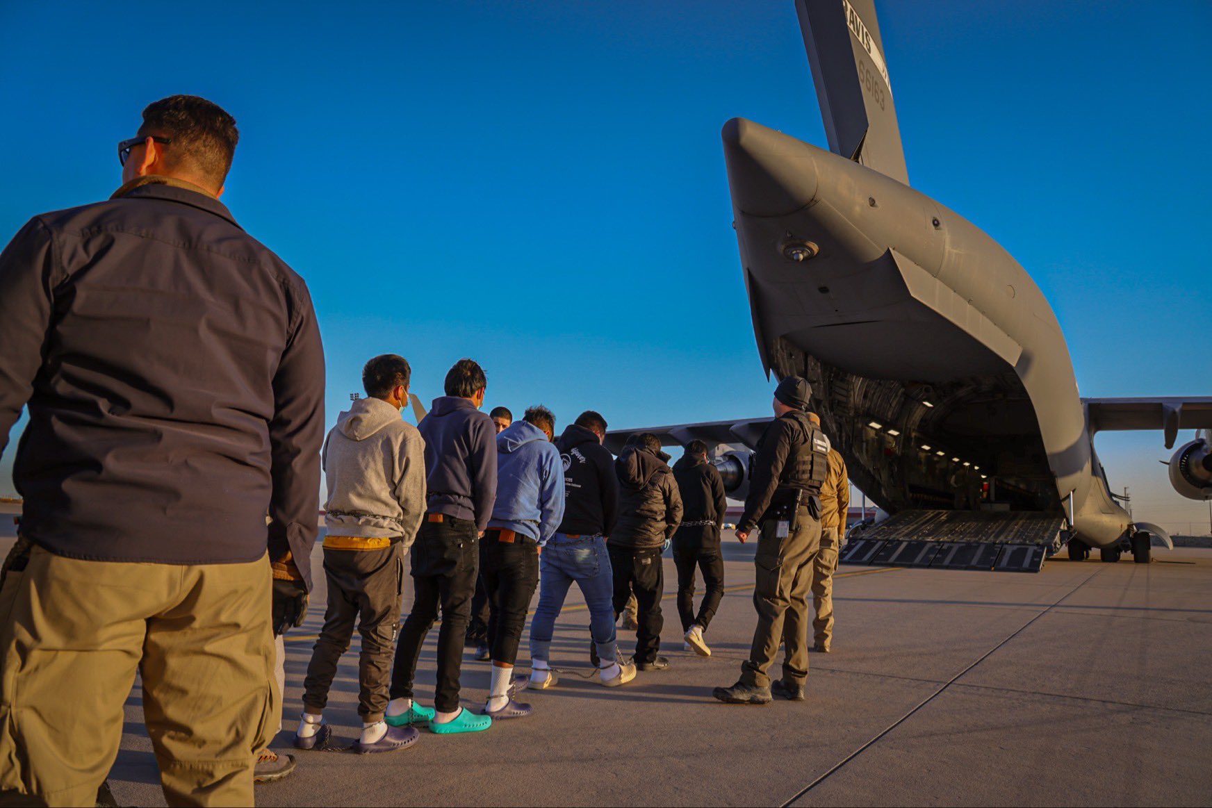 In January 2025, migrants wait to board a deportation flight (US Government/Wikimedia Commons)