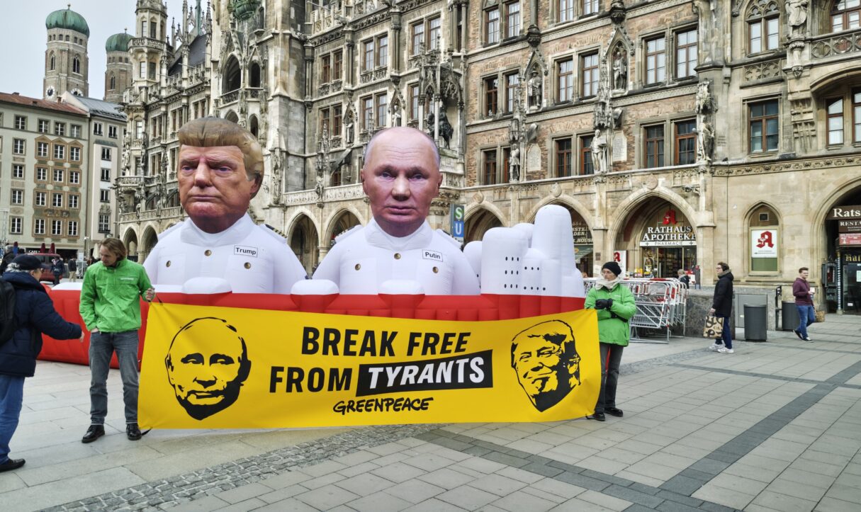 During a Greenpeace rally during the Munich Security Conference in 2026, demonstrators hold a banner describing Trump and Putin as 'tyrants' (Wikitarisch/Wikimedia Commons)