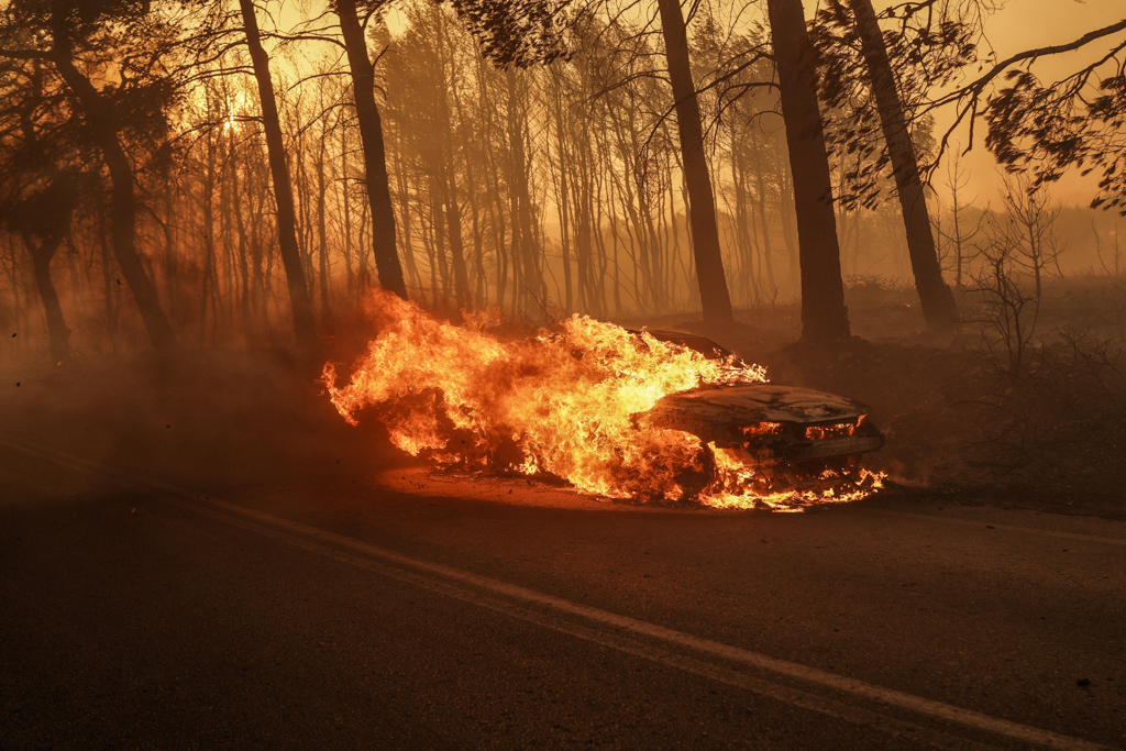 A car goes up in flames near Varnavas, in northeastern Attica, on Aug. 11 (Nick Paleologos)