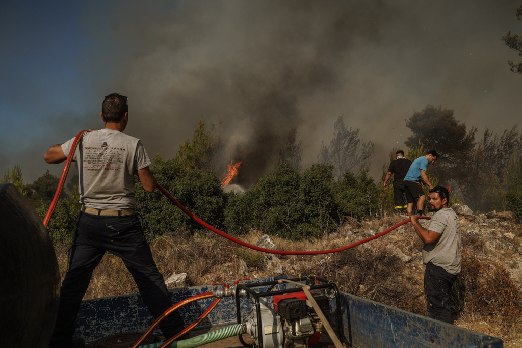 Local residents used hoses to quell the fires near Stamata in July (Nick Paleologos)