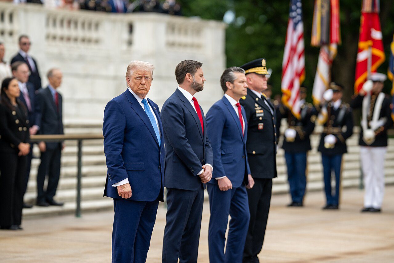 US President Donald Trump, Vice President JD Vance, and Defense Secretary Pete Hegseth participate in a ceremony in May 2025 (Daniel Torok/Wikimedia Commons)