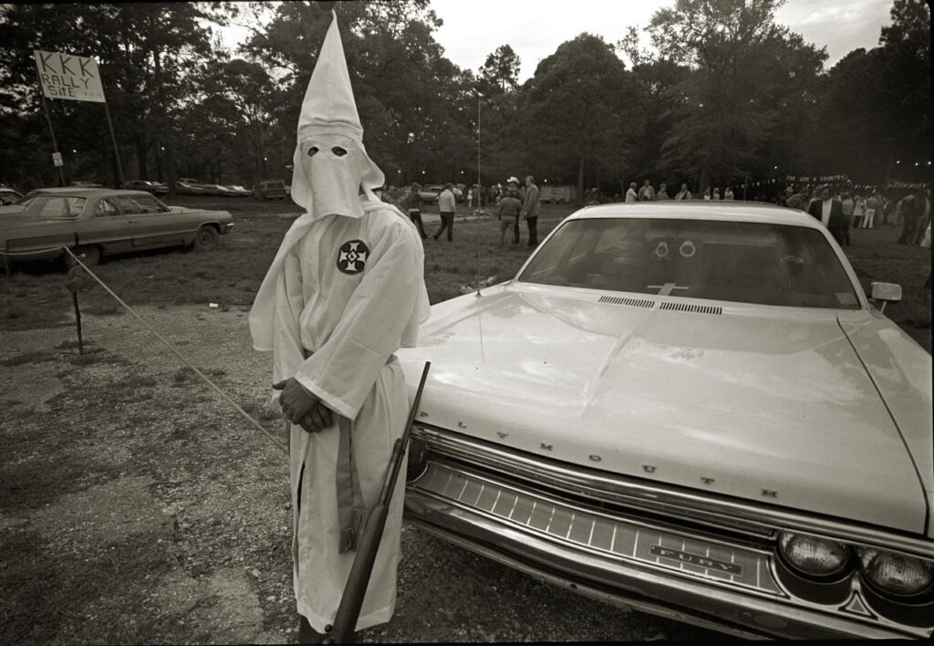 A photo shows an armed guard on the perimeter of a Klan rally in Vidor, Texas, in 1975 (Moody College of Communication/Wikimedia Commons)