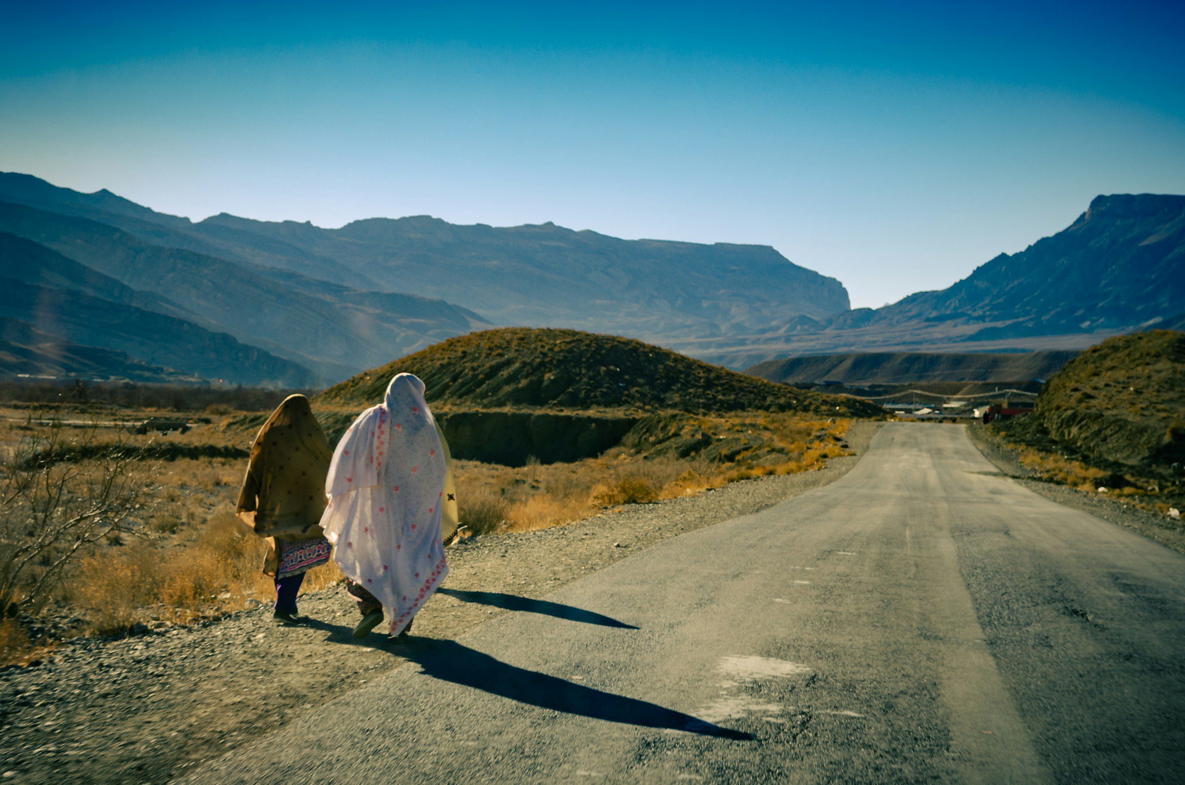 Two women walk along a road near Quetta, in Pakistan's Balochistan province (Muhammed Amer via Unsplash)