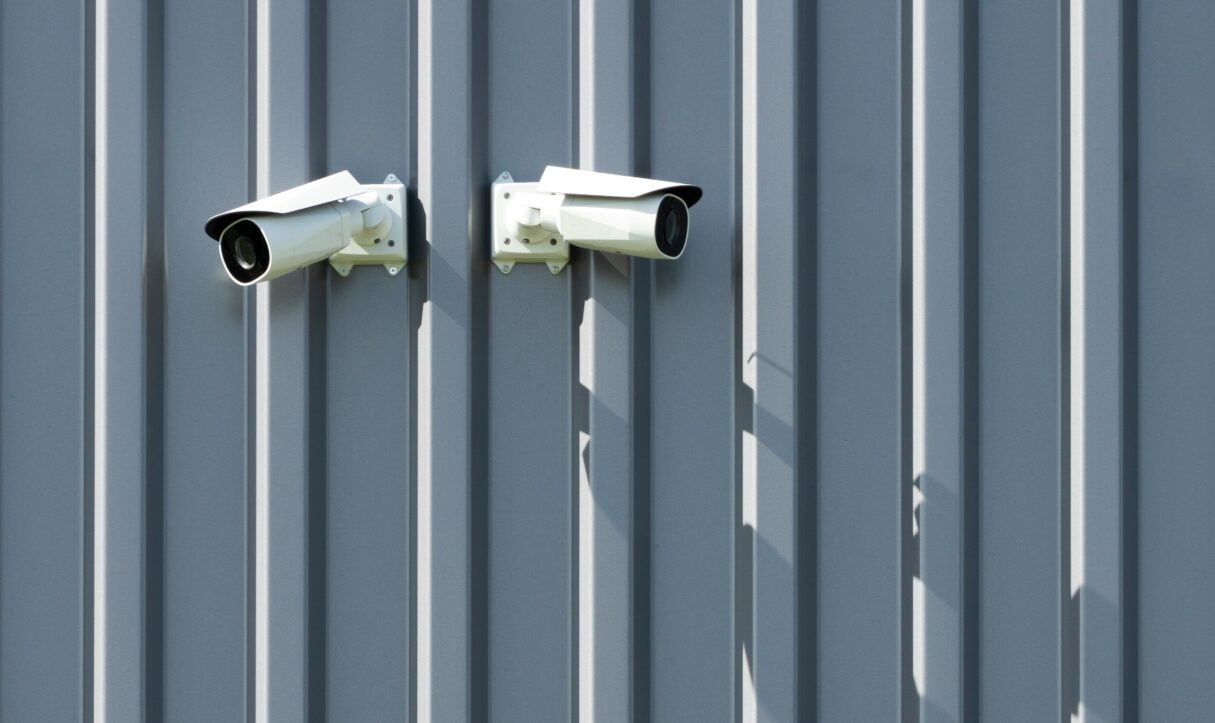 A photo from May 2022 shows a pair of security cameras fastened to a wall (Fer Troulik/Unsplash)