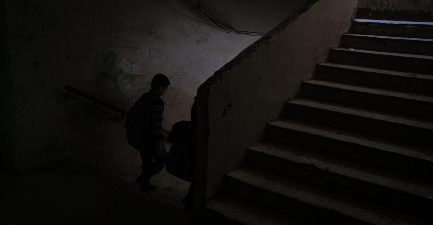 Children walk down a stairway inside the former Gaza Hospital building (João Sousa)