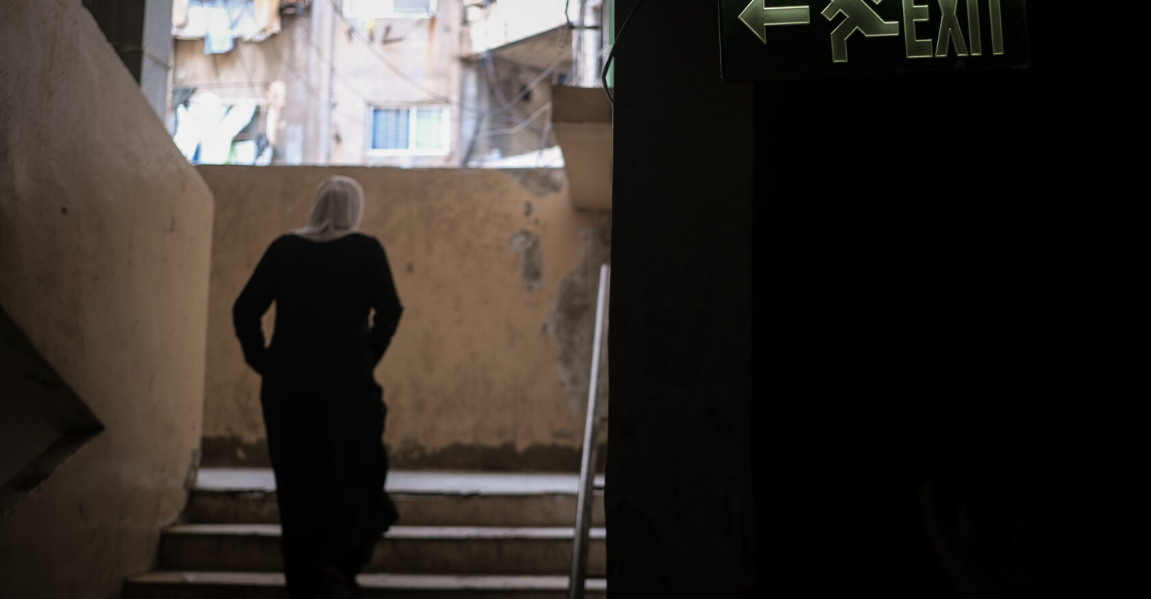 A woman walks down a stairway inside the former Gaza Hospital building (João Sousa)