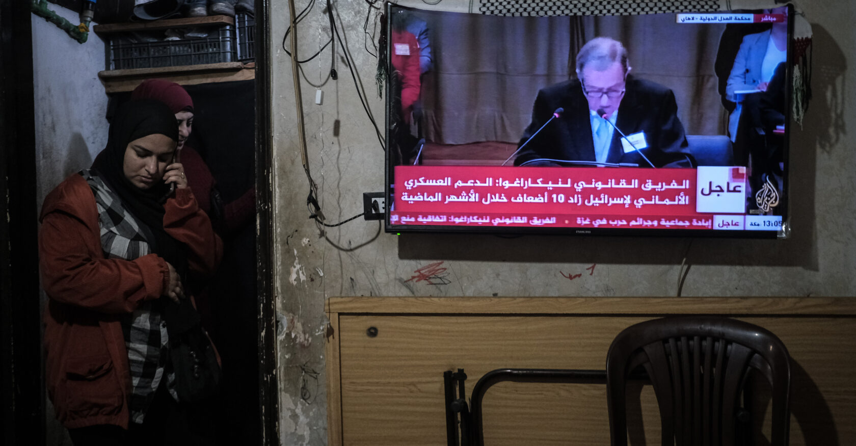 A family watches the news in their makeshift living room in the former Gaza hospital on April 8, 2024 (João Sousa)