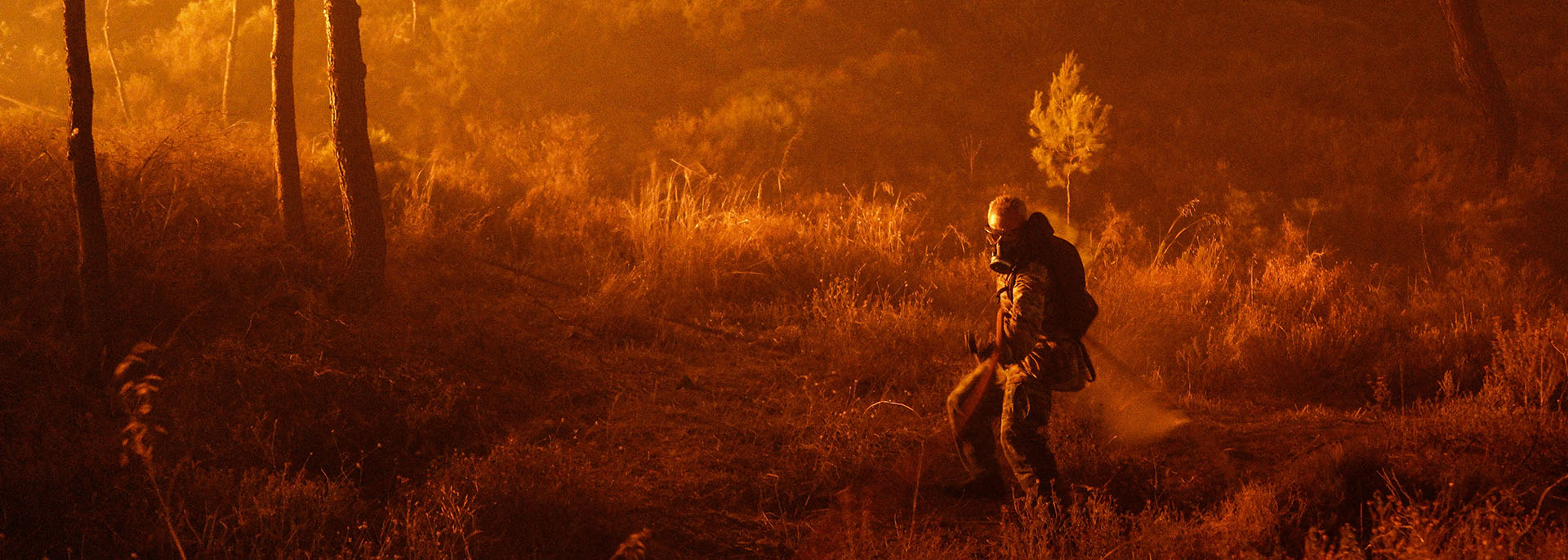 A volunteer firefighter approaches a blaze in the wooded areas near Dionysos, in northern Attica (Nick Paleologos)