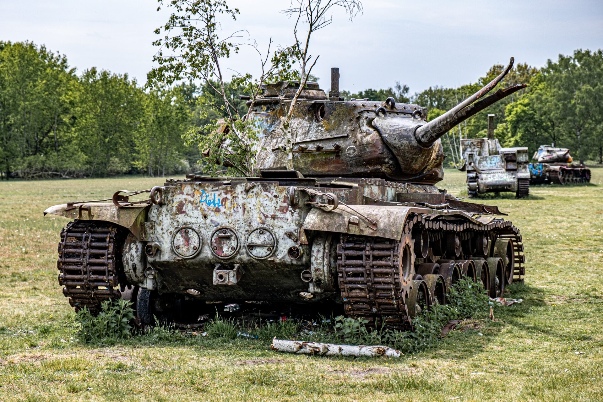 In Langenhagen, Germany, abandoned tanks sit in a clearing surrounded by trees (Joshua Kettle/Unsplash)
