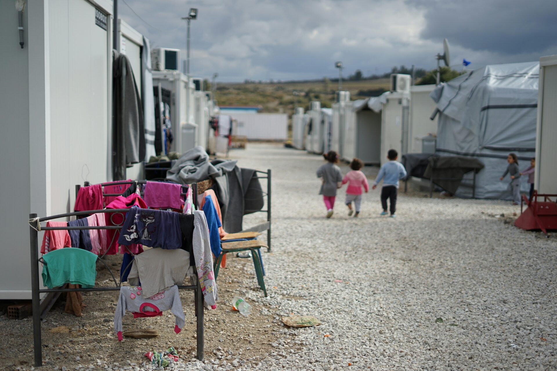 Syrian refugee children walk through a camp on the outskirts of Athens, Greece, in 2020 (Julie Ricard/Unsplash)
