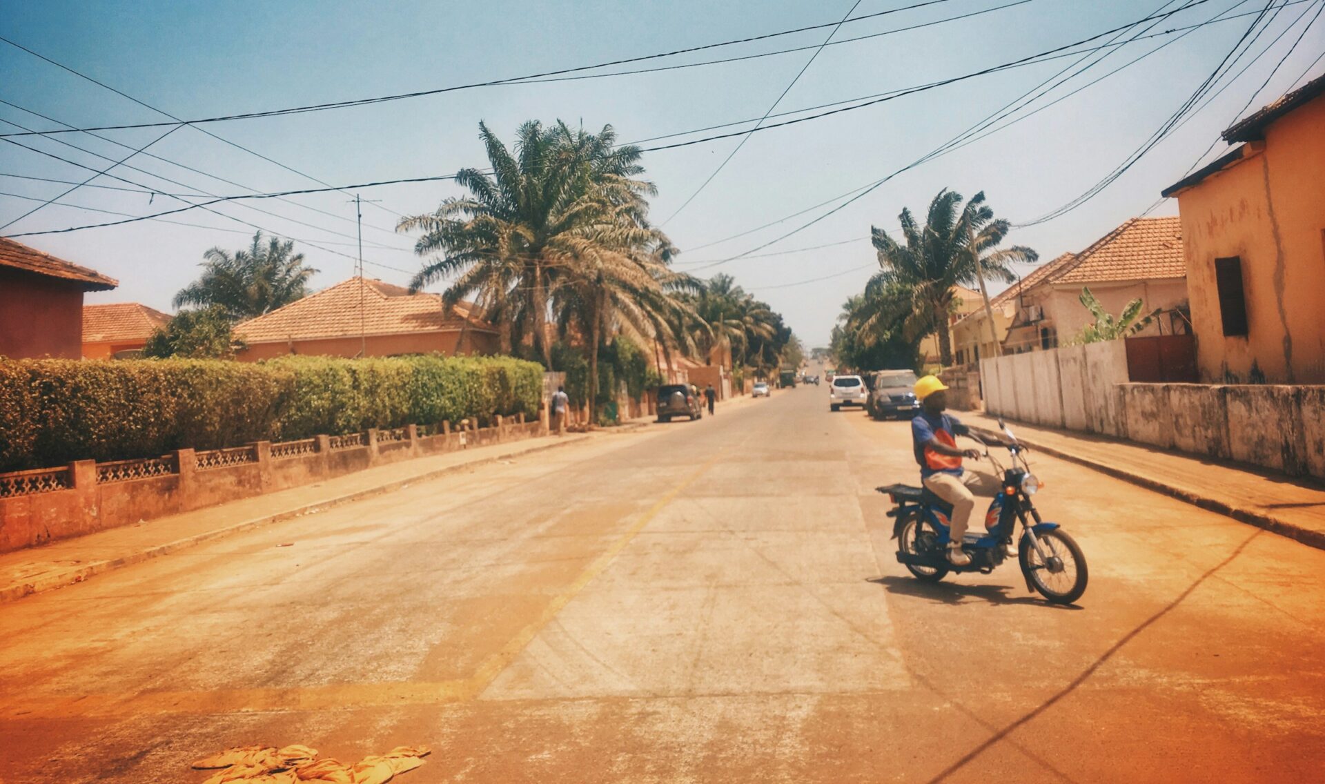 A young man rides a motorbike on a street in Bissau (Kaysha via Unsplash)