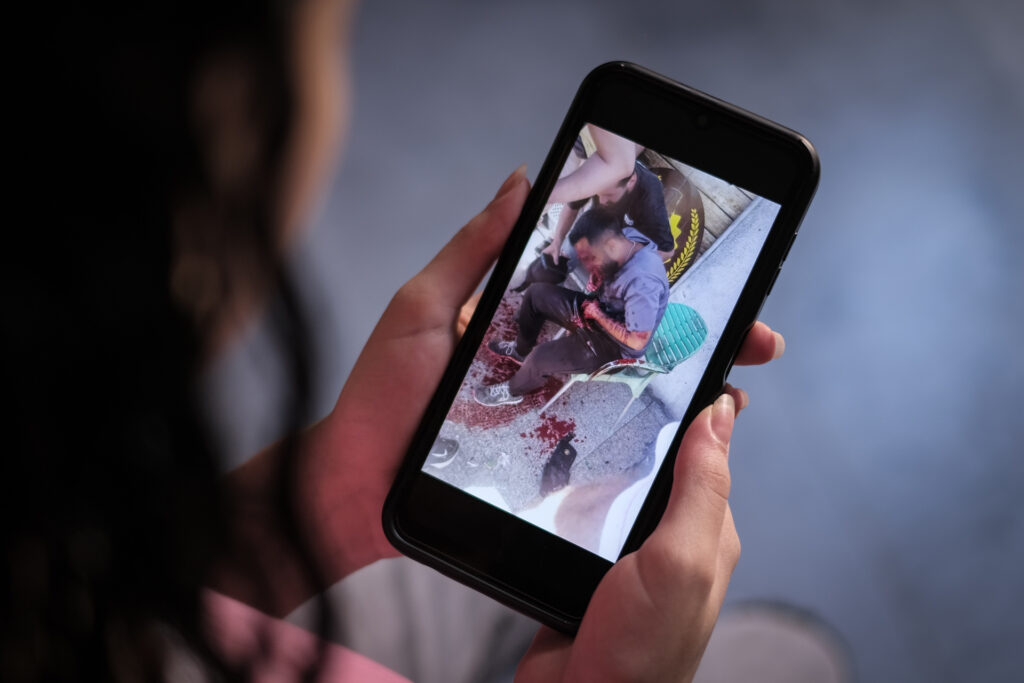 A cousin of twin sisters Mariam and Marwa looks at a photo of one of the victims of this week’s pager explosions in Lebanon on Sept. 17, 2024 (João Sousa)