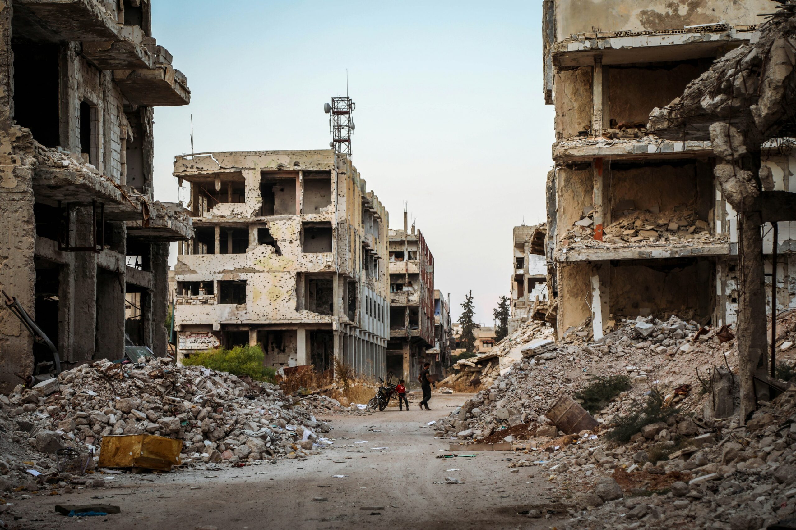 In Syria's Daraa, children cross a rubble-strewn street in January 2022 (Mahmoud Sulaiman/Unsplash)