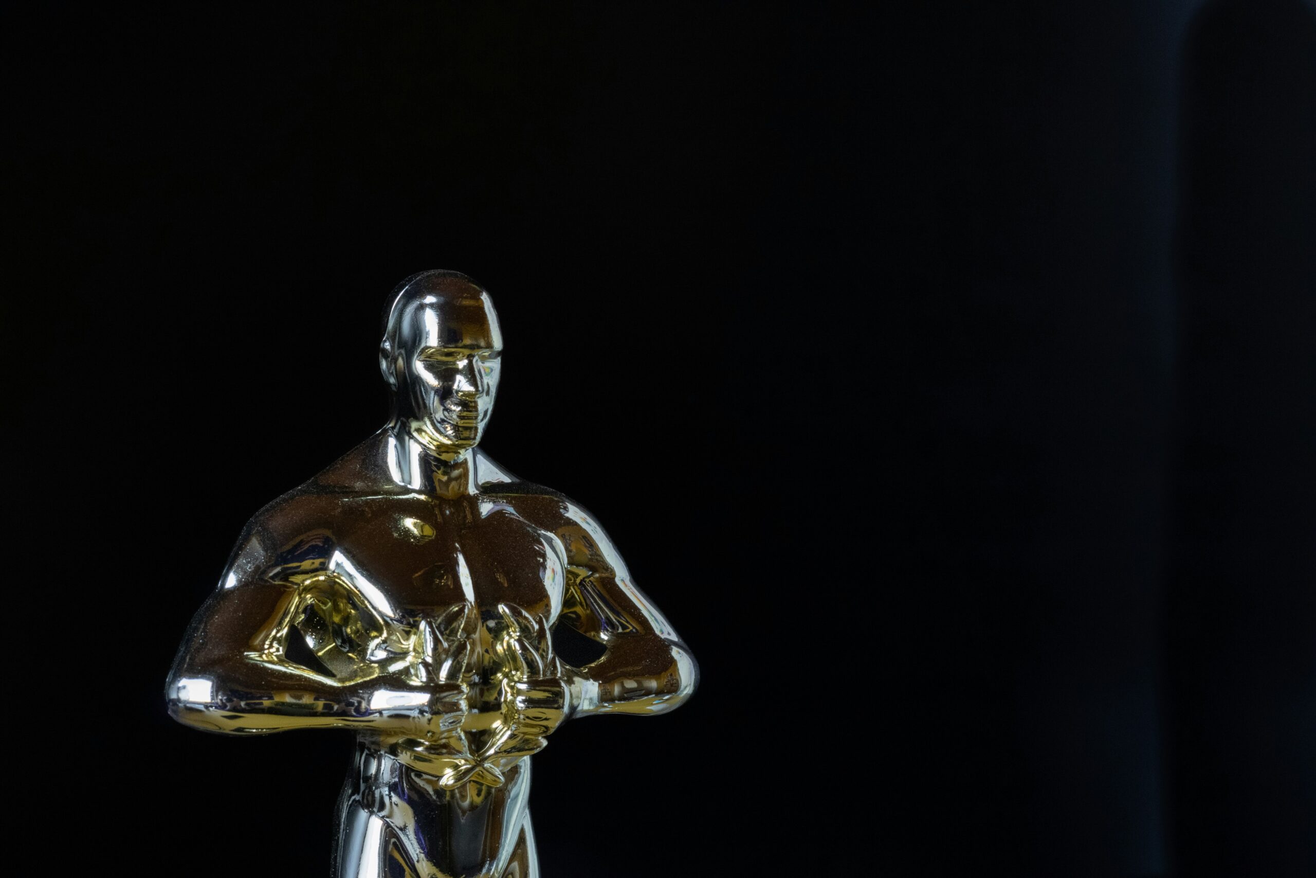 An Academy Award is photographed against a black background (Mirko Fabian via Unsplash)