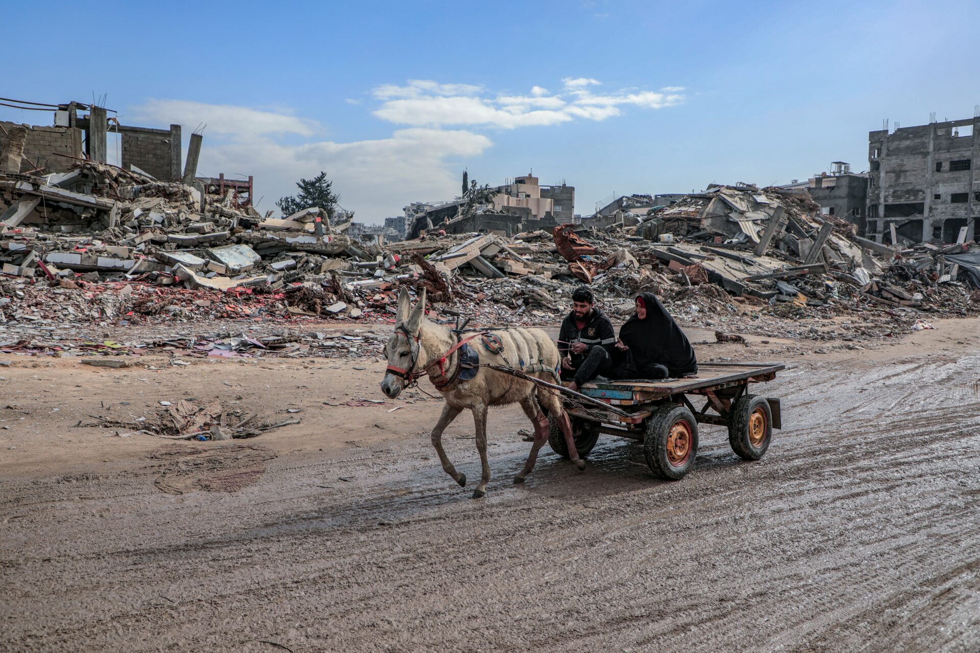 A young man and his mother ride on a donkey-led cart through the destruction of Gaza's Jabalia camp in June 2025 (Mohammed Ibrahim/Unsplash)
