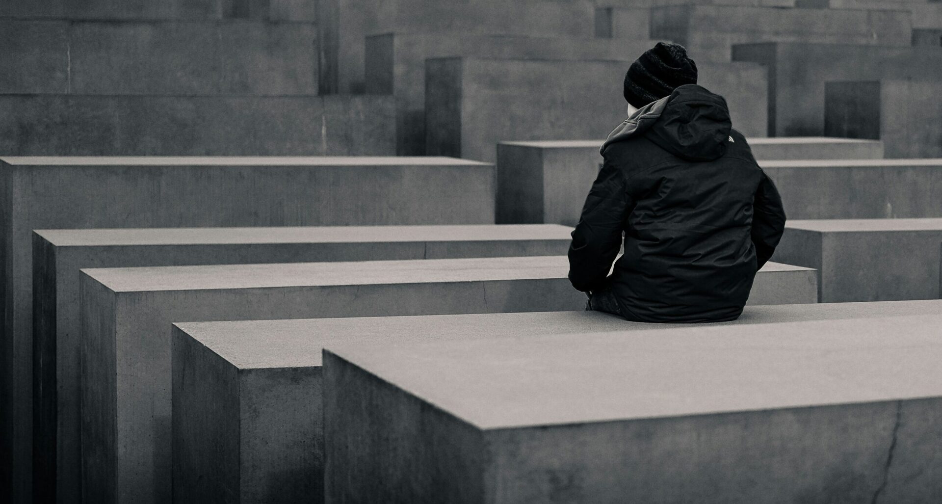 A child sits at a Berlin Jewish memorial (Moritz Schumacher via Unsplash)