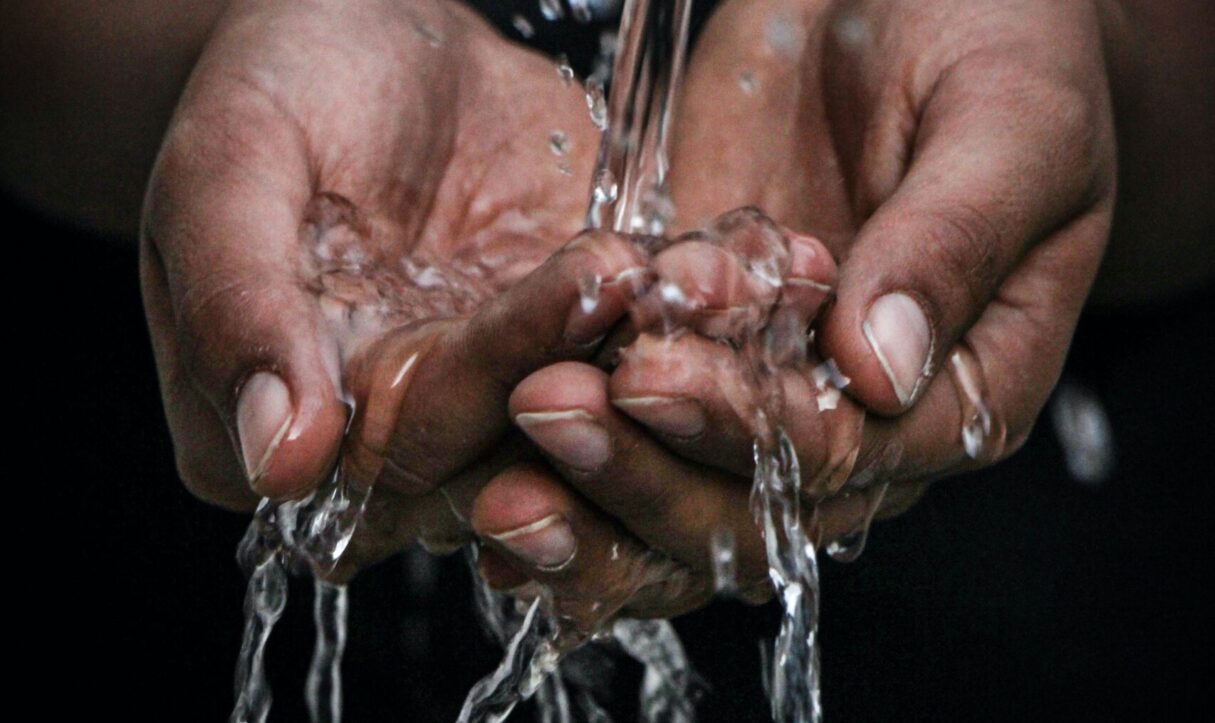 Hands with water pouring over them
