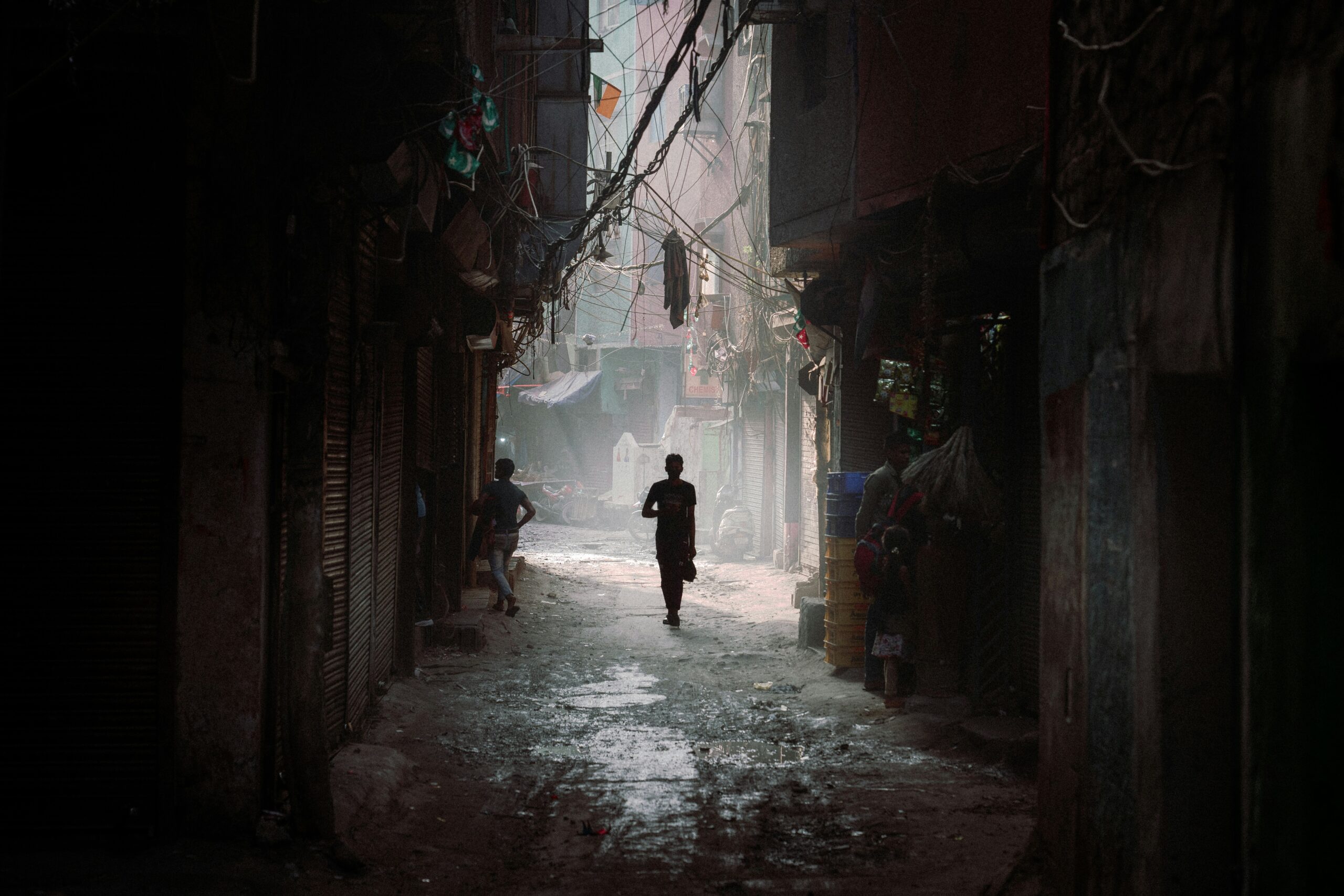 Young boys walk through tight alleyways in New Delhi, India, in May 2023 (Touann Gatouillat Vergos/Unsplash)